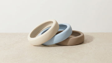 Three smooth silicone rings in neutral tones on a clean surface — beginner's guide to cock rings
