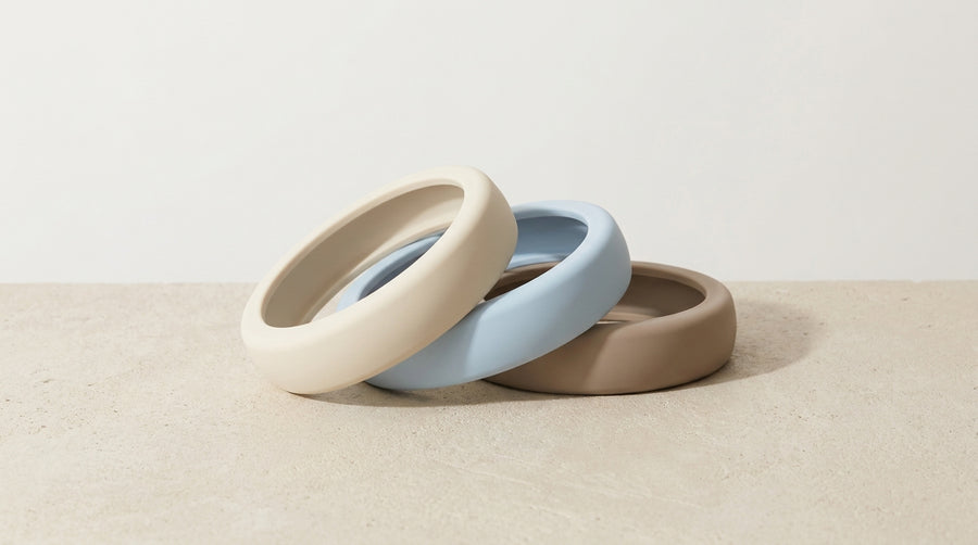 Three smooth silicone rings in neutral tones on a clean surface — beginner's guide to cock rings