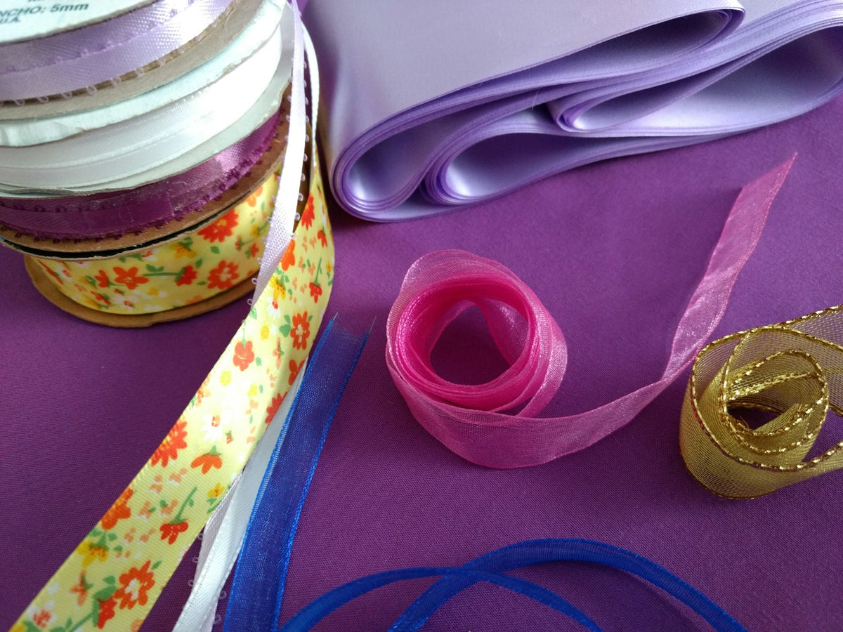 Soft pastel lace ribbons coiled on a neutral background — intentionality and care.