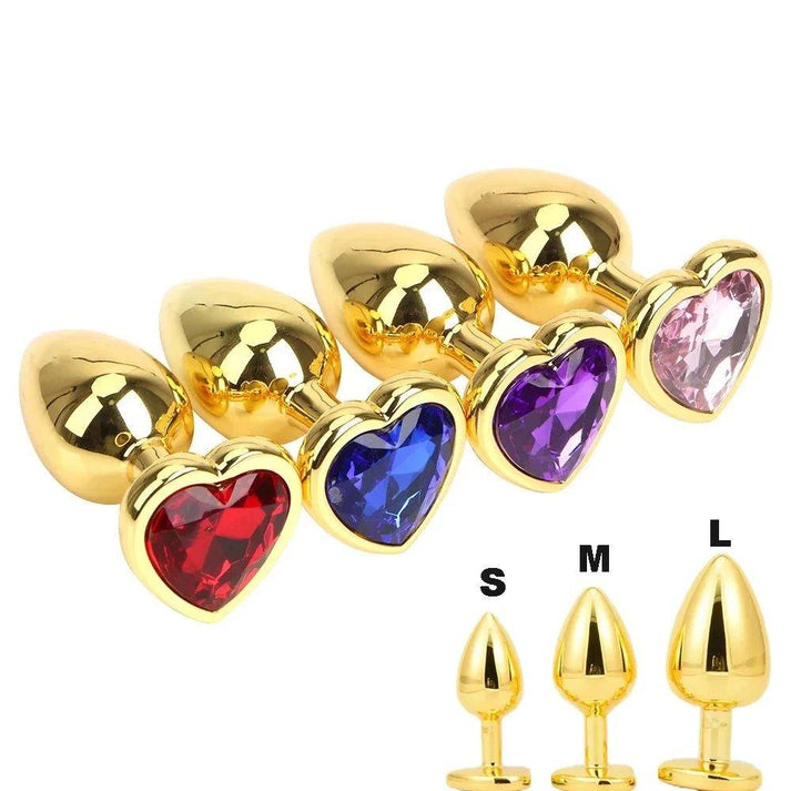 Gold-plated metal butt plug with heart-shaped base, shown in three sizes