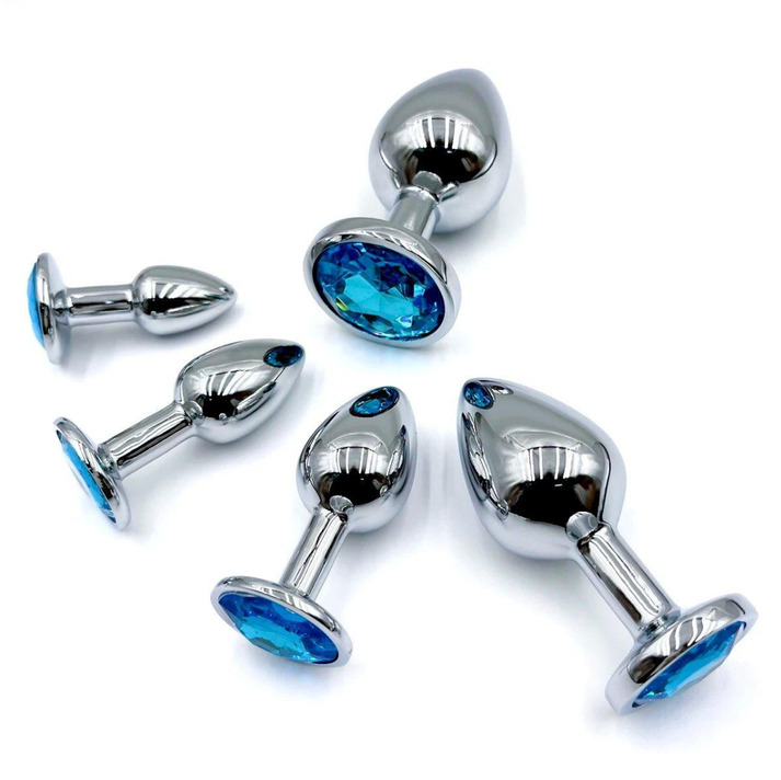 Polished metal butt plug with tapered tip and sparkling gem in the base